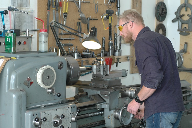 Employee metal-working on equipment